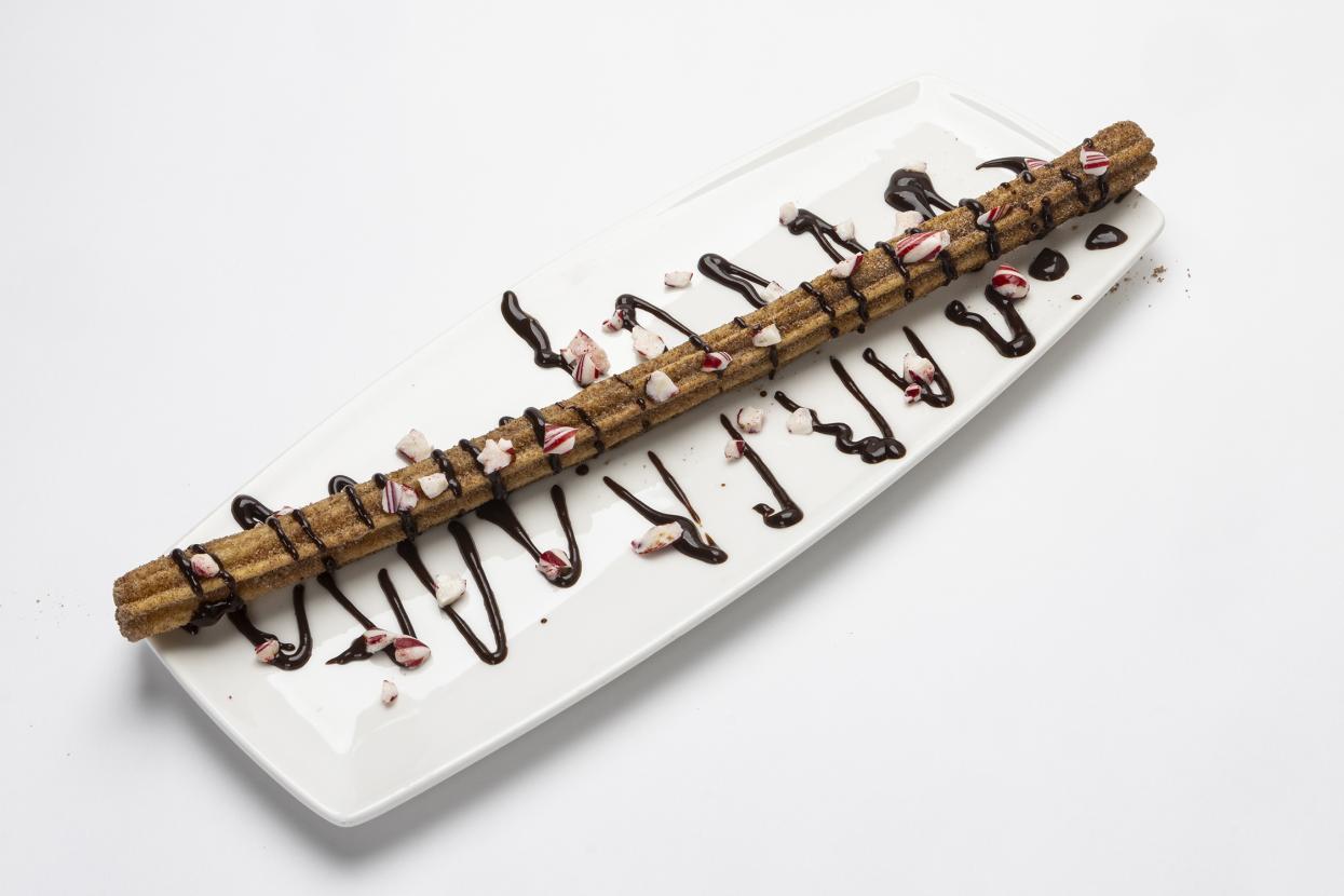 Churro with chocolate drizzle and peppermint crumbles