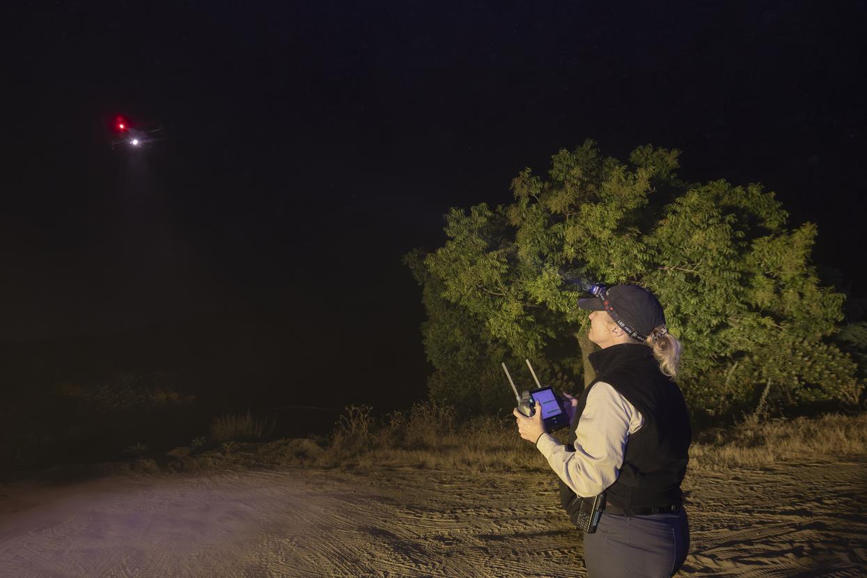 Nighttime view of woman operating drone