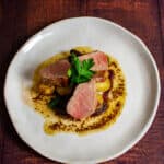 pork tenderloin, vegetables & honey mustard sauce on a white plate