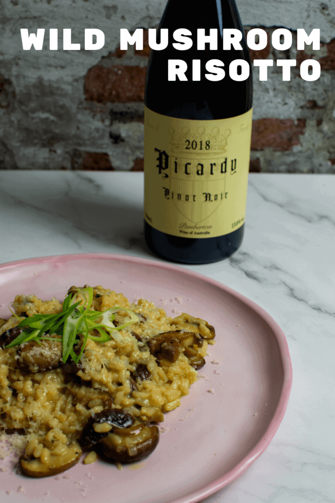 wild mushroom risotto on pink plate with a btl of picardy pinot noir