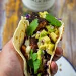 someone holding a blackened salmon taco