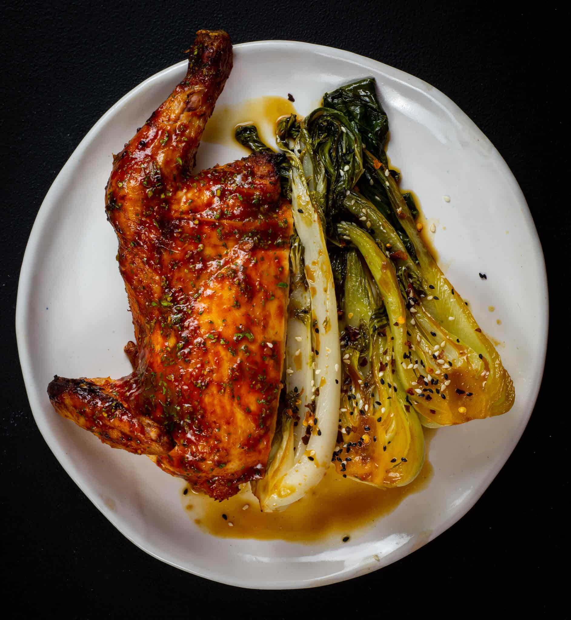BBQ Korean Chicken on a white plate with Asian vegetables 
