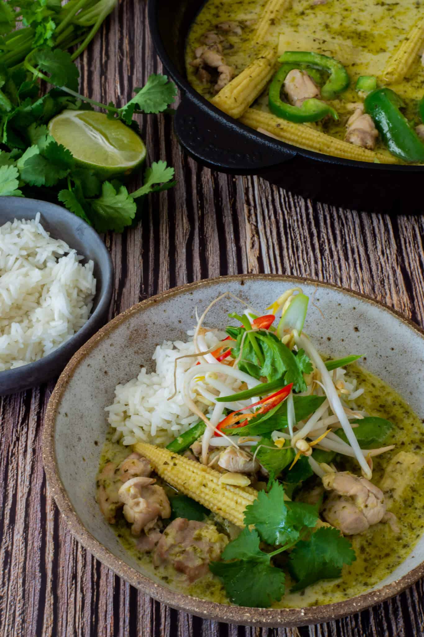 thai green curry, rice, herbs & lime on a table