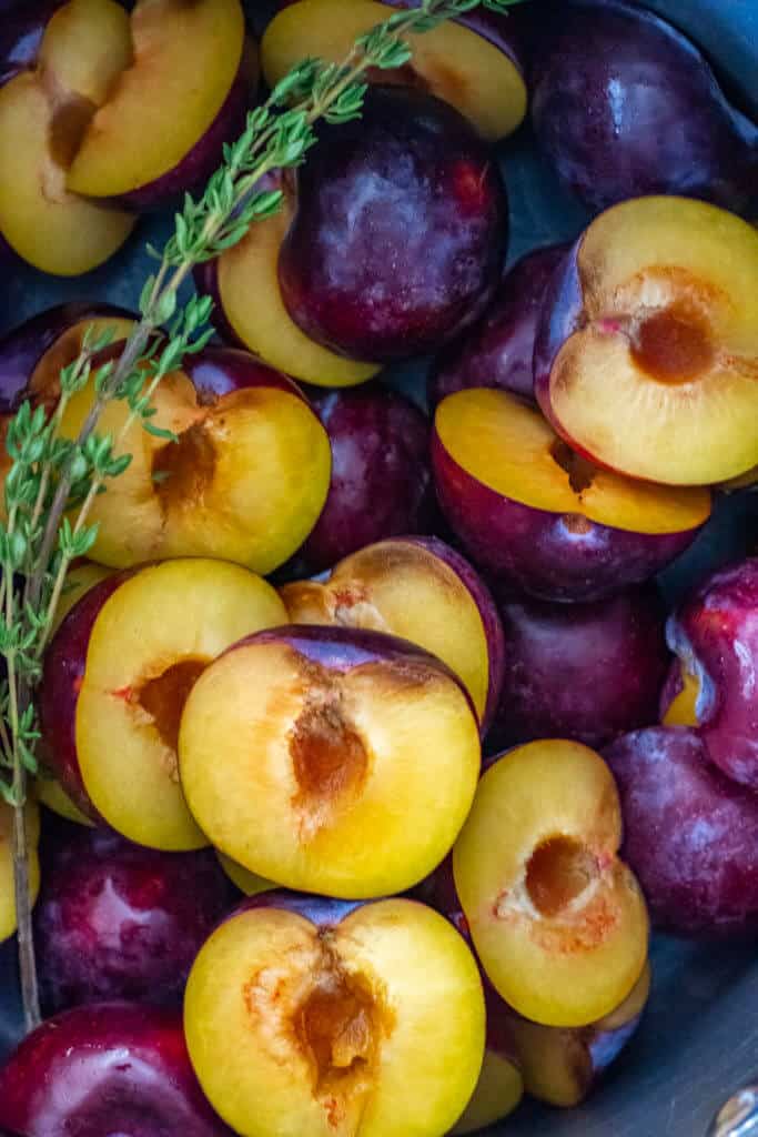 plums and thyme in a saucepan