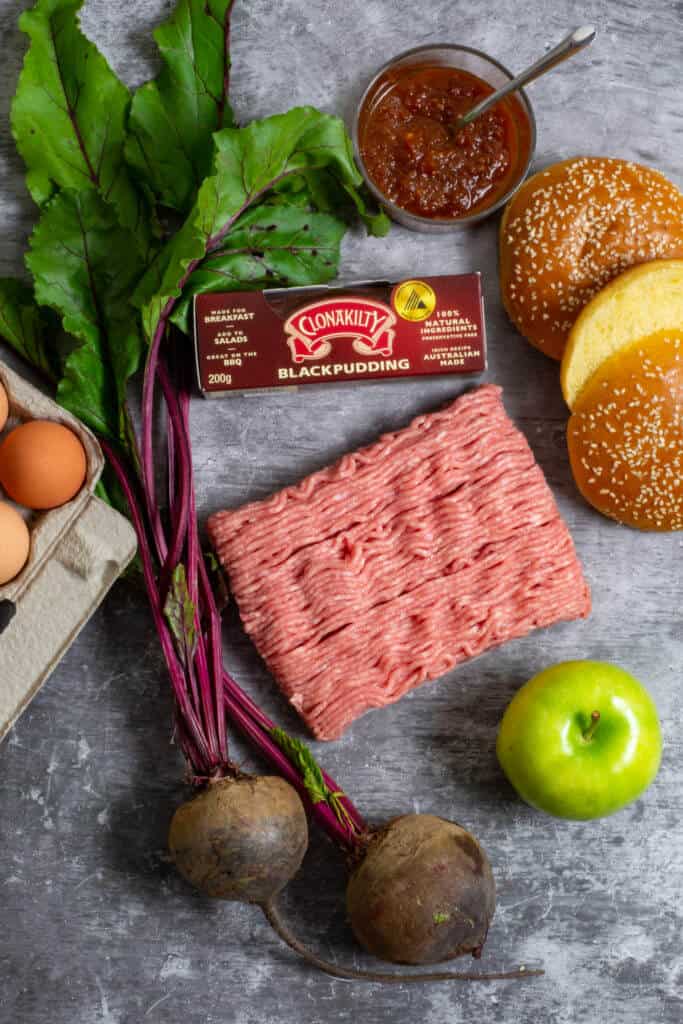 Pork mince, beetroot, apple, black pudding and eggs on a board