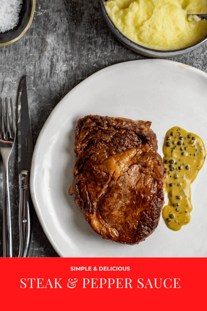 Rib fillet, pepper sauce, mashed potatoes and cutlery on a table