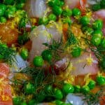 Raw fish, peas & dill in a pan for fish pie