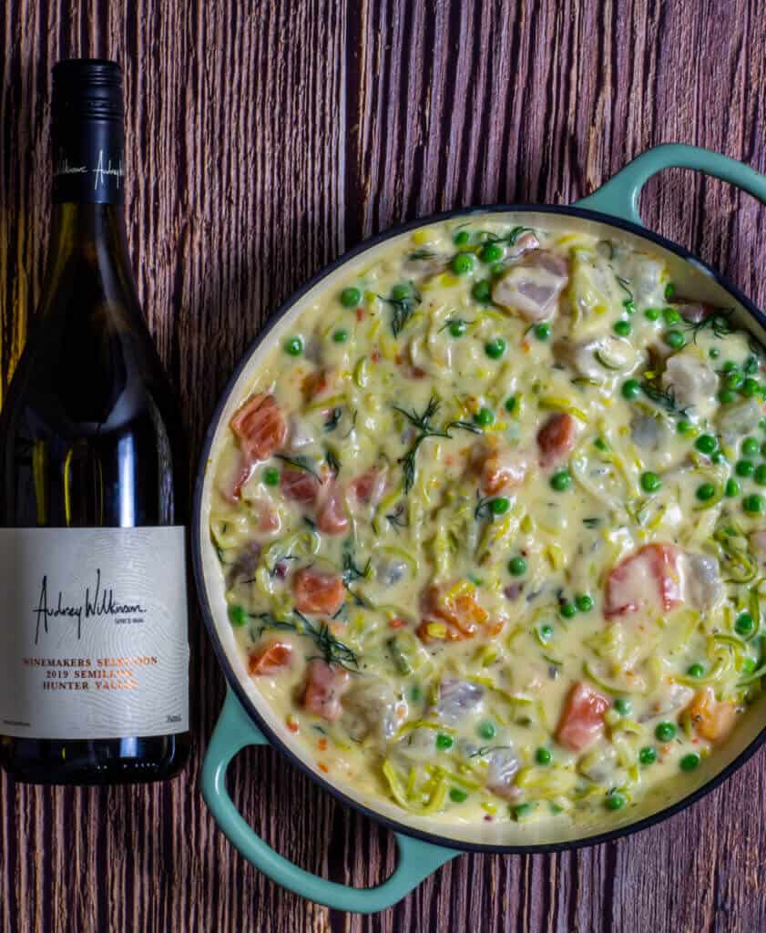 fish pie in pan with wine beside it