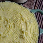 uncooked fish pie topped with mash potatoes and wine bottle