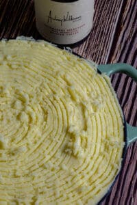 uncooked fish pie topped with mash potatoes and wine bottle