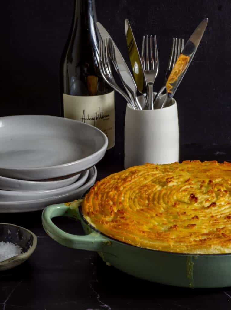 fish pie, wine bottle, plates and cutlery
