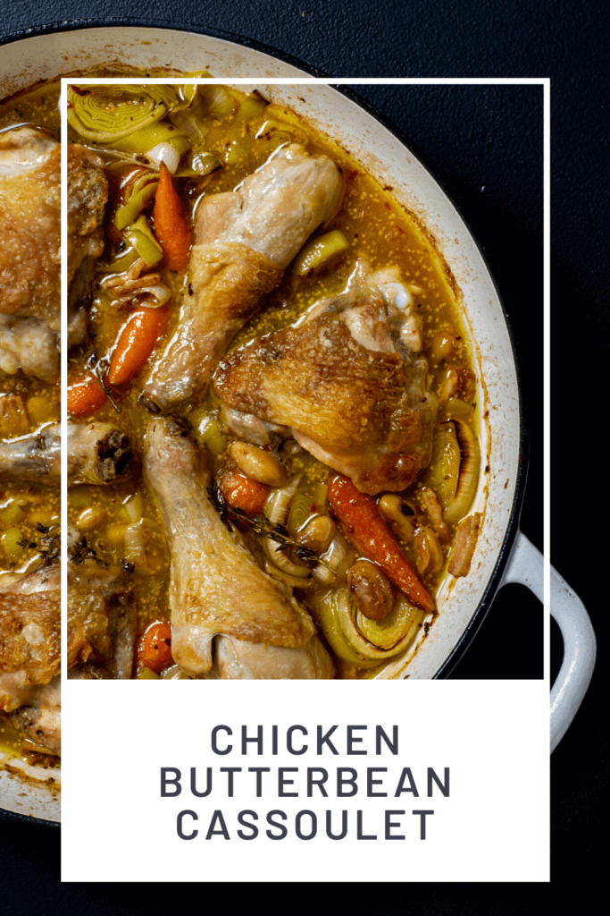 Cooked chicken cassoulet in white shallow proof casserole dish