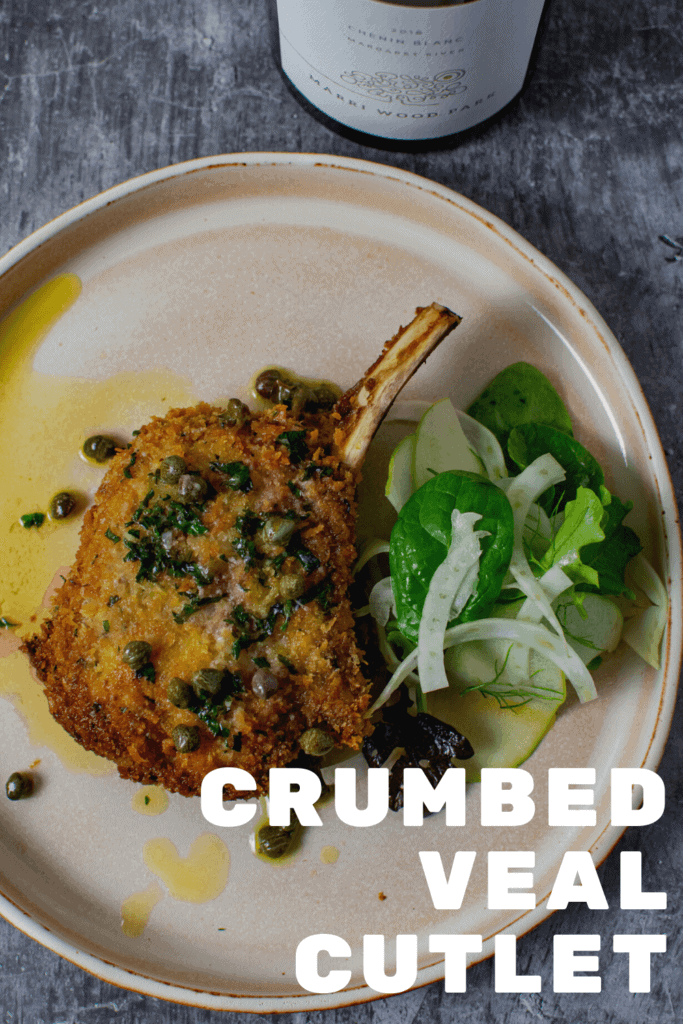 cooked veal cutlet, salad & sauce on a plate