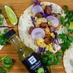 chorizo & prawn tacos on chopping board with sabarac hot sauce
