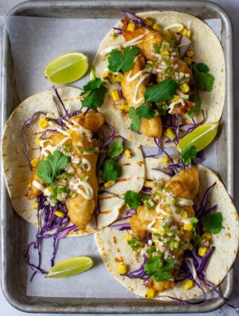 birdseye view of 3 crispy fish tacos on a tray