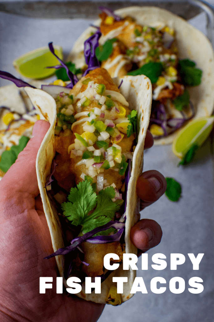someone holding a crispy fish taco