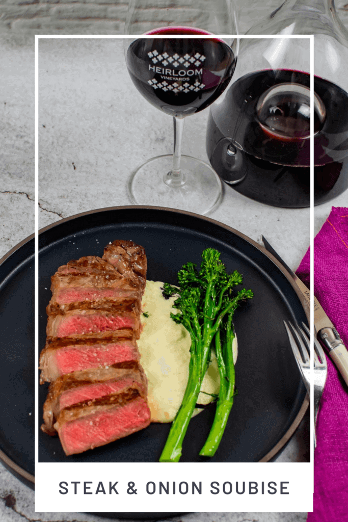 steak & onion soubise on a plate, decanter, glass of wine