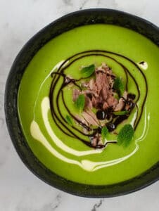 A bowl of pea & ham soup on kitchen countertop