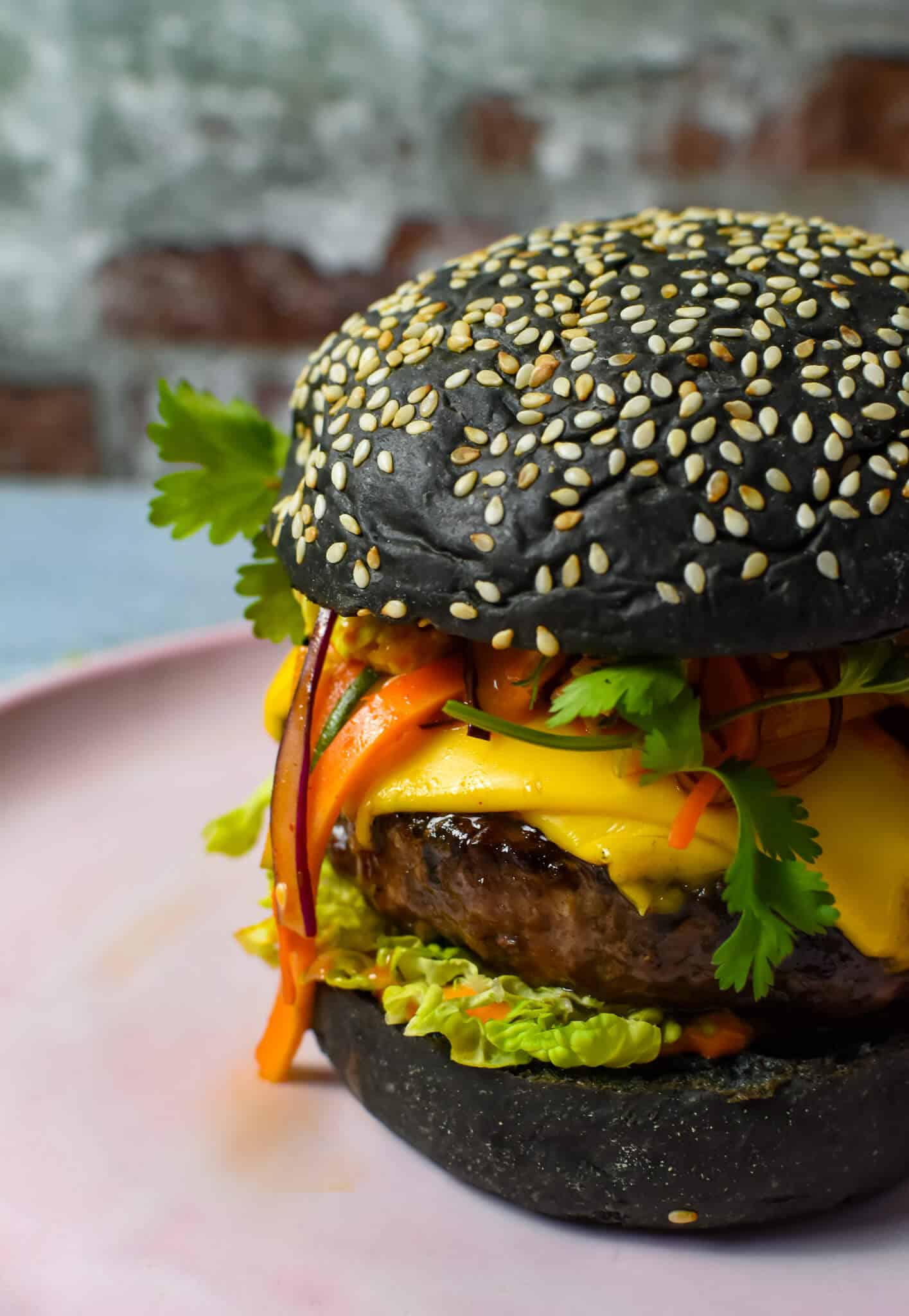 angled view of korean beef burger on a pink plate