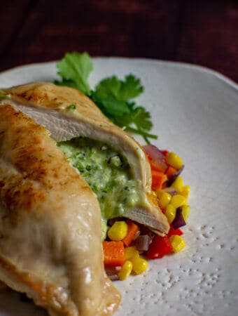 jalapeno popper stuffed chicken on white plate with corn hash