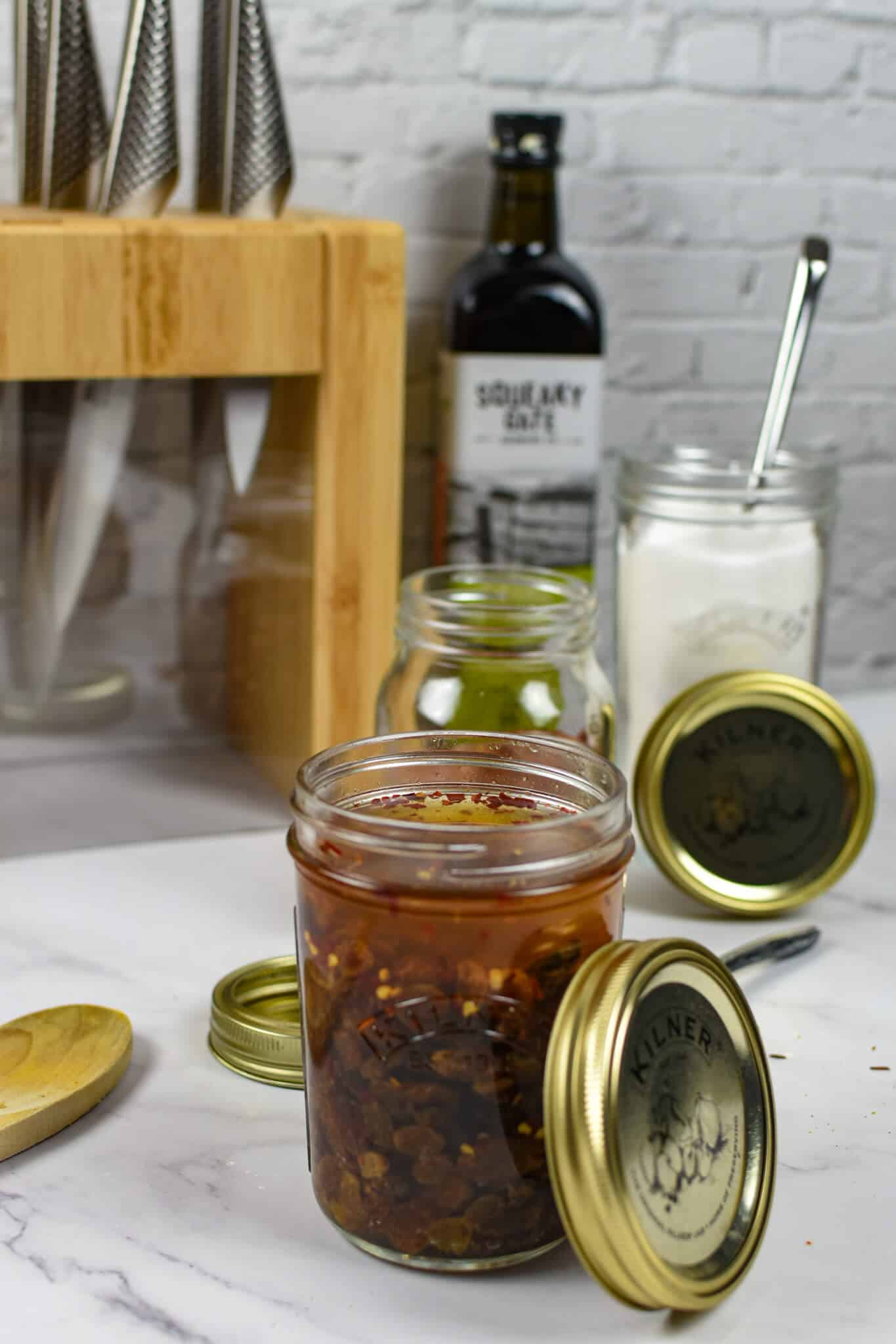 pickled raisins in kilner jar, global knived in background and sugar in a kilner jar