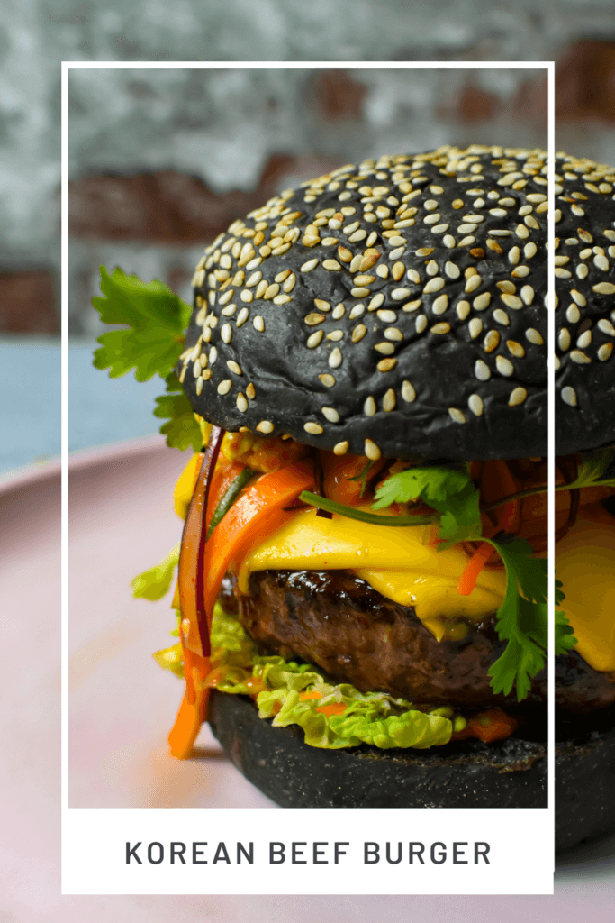 angled view of korean beef burger on a pink plate