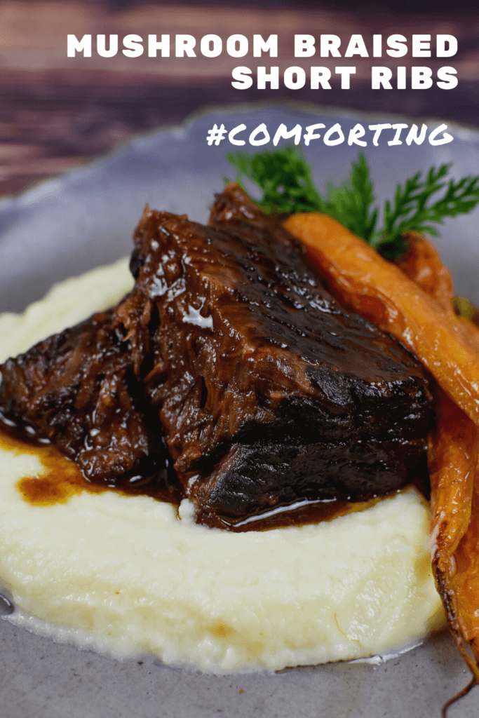 mushroom braised short ribs, cauliflower puree & carrots in a bowl on wooden table