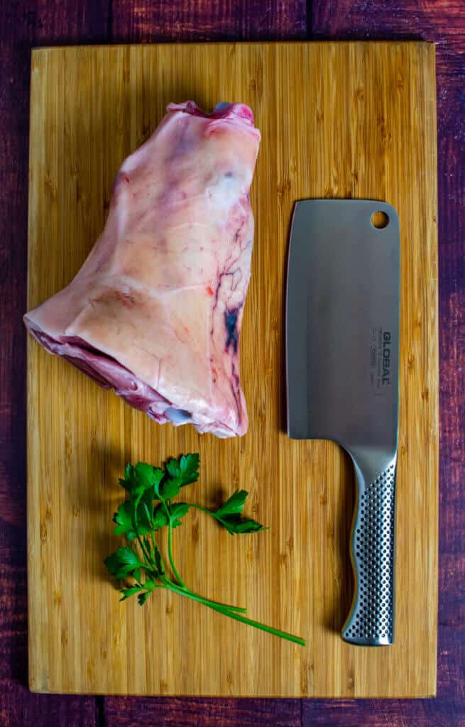 ham hock & a global meat cleaver on a chopping board