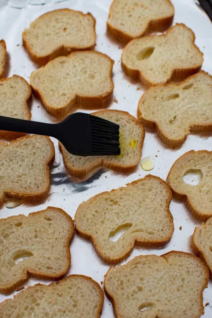 french baguette being brushed with olive oil