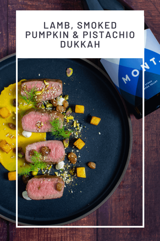 lamb, smoked squash puree, & pistachio dukkah on a black plate with mont wines syrah next to it