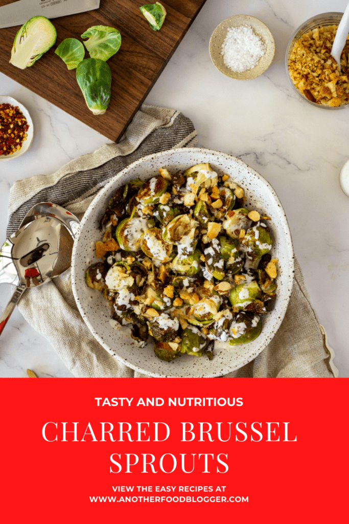 charred brussel sprouts & pangrattato in a bowl with a chopping board, brussel sprouts in the background
