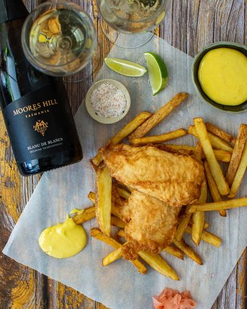 battered fish & chips, aioli, moores hill blanc de blanc wine & salt on a wooden table