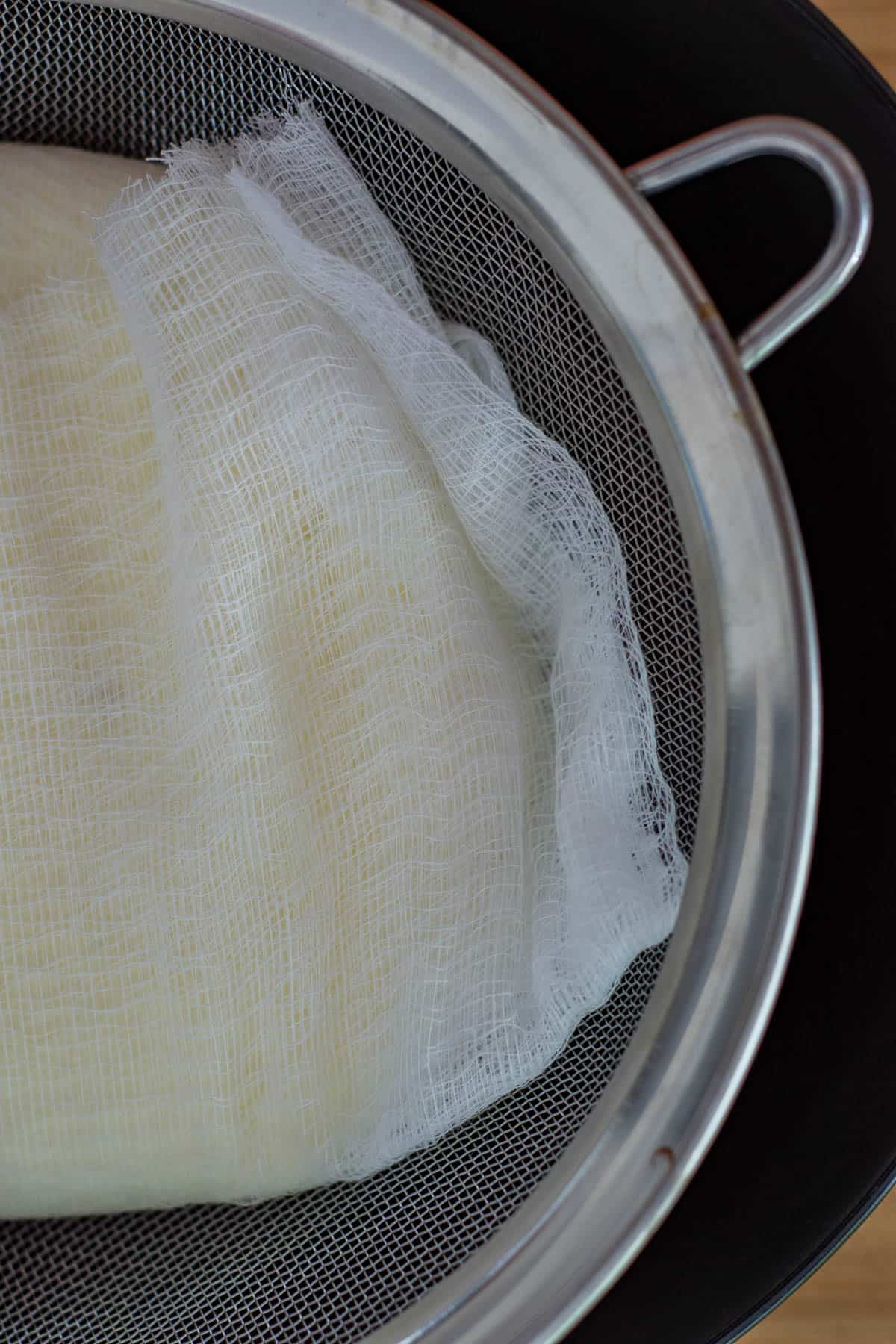 labneh in a muslin cloth in a sieve