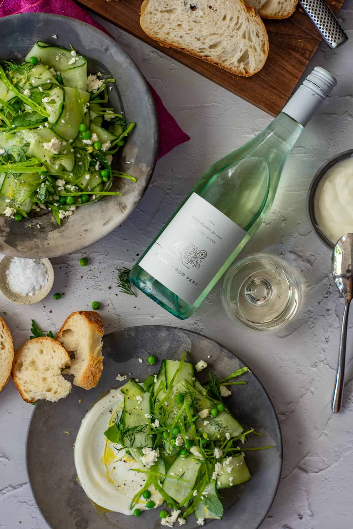 English pea salad on a plate, sourdough bread & Marri wood park sauvignon blanc