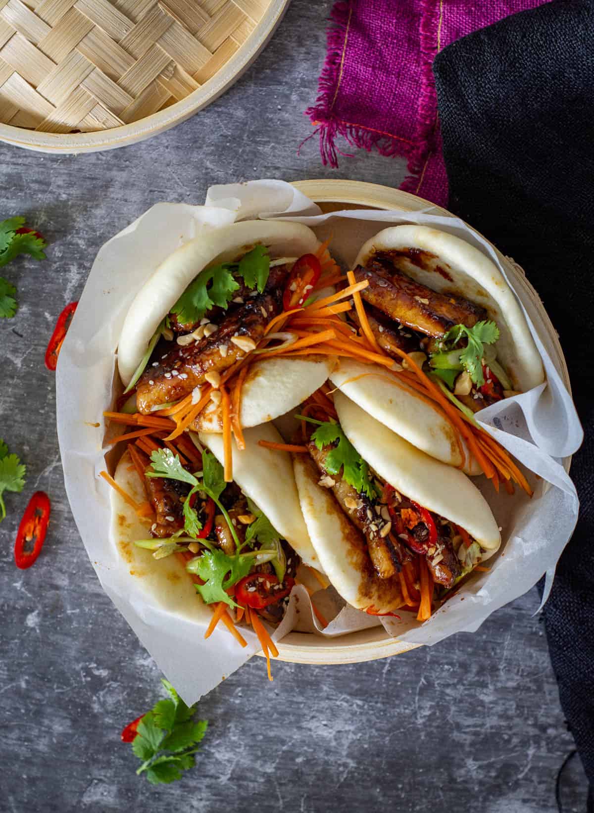 steamed pork bellu bao in a bamboo steamer
