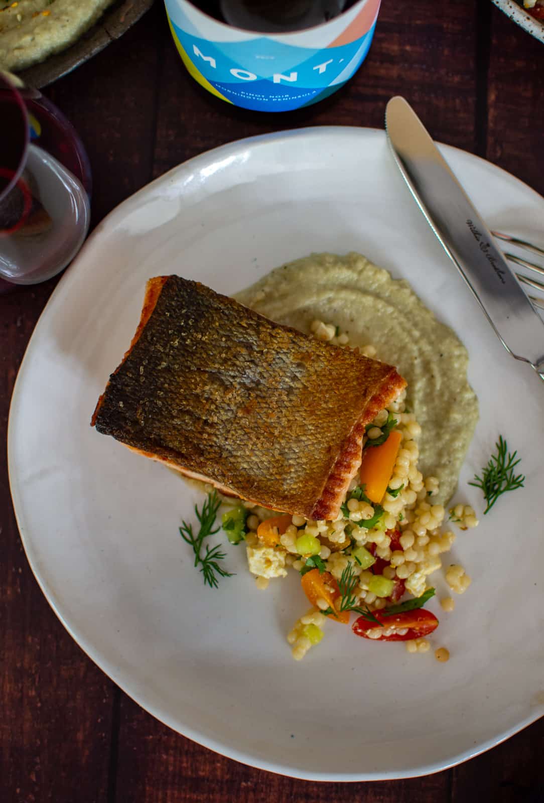 moroccan salmon on a plate with mont pinot noir next to it
