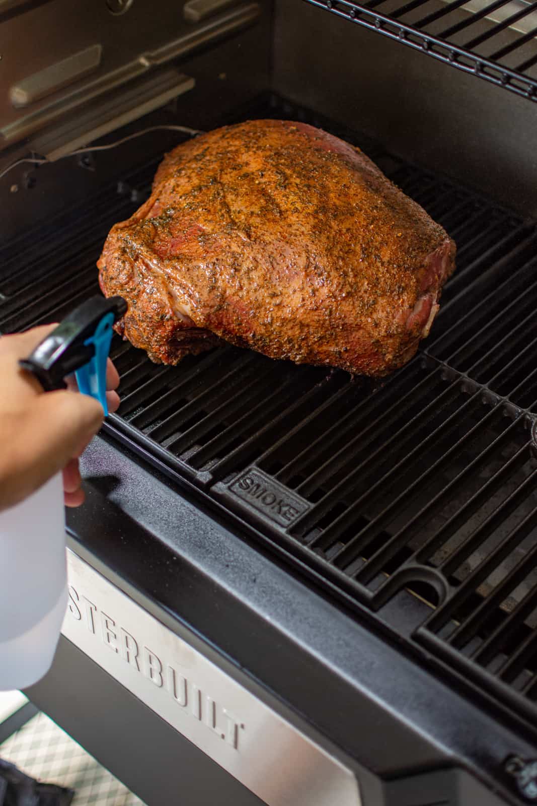 smoked lamb shoulder being spritzed