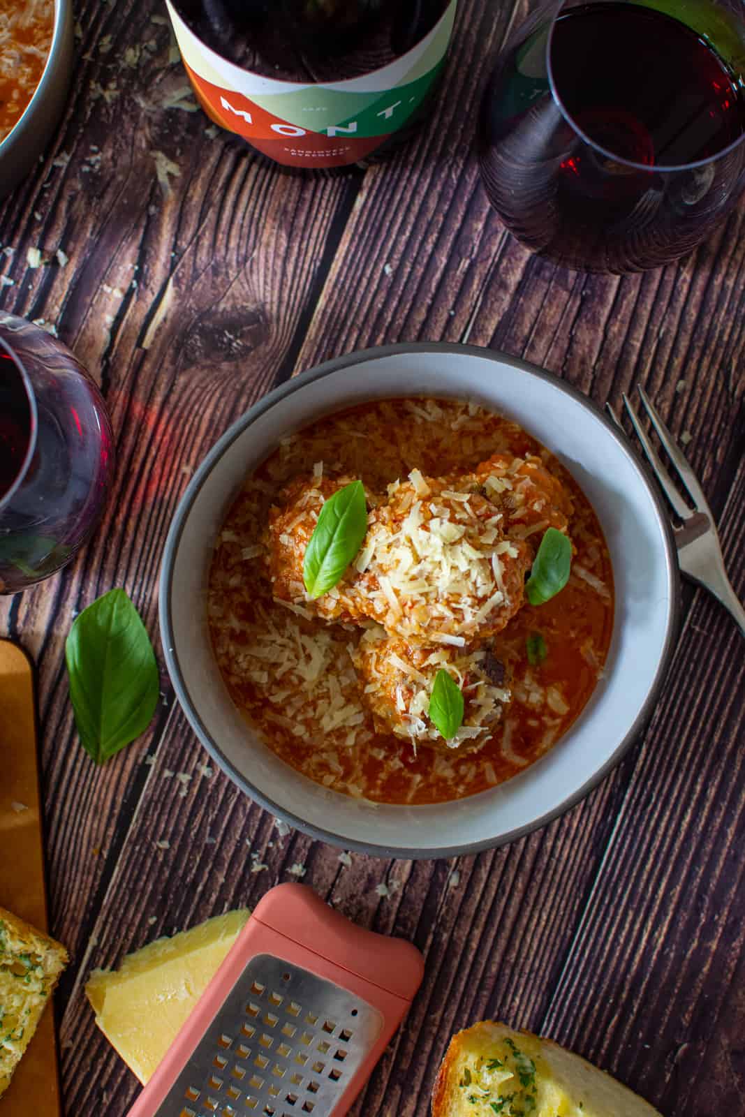 bowl of pork & beef meatballs, marinara sauce, parmsan and some wine