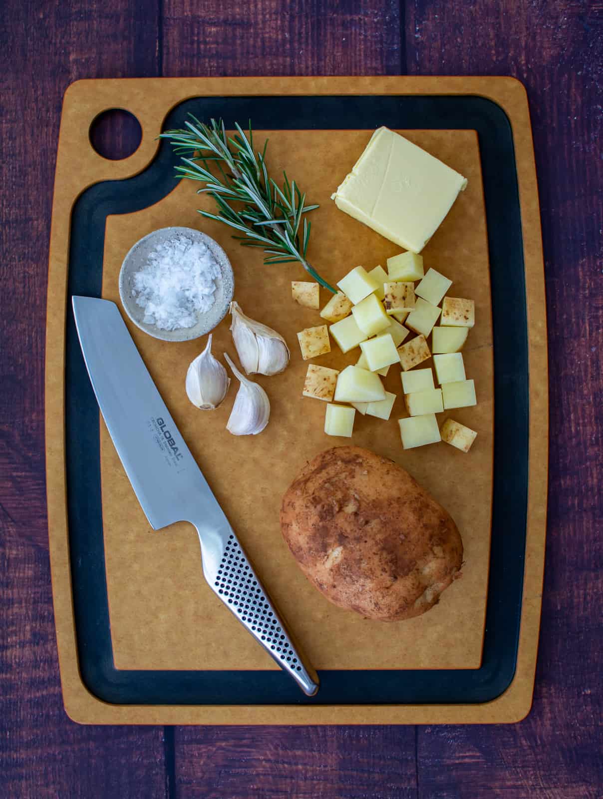 potatoes, herbs & butter on a chopping board