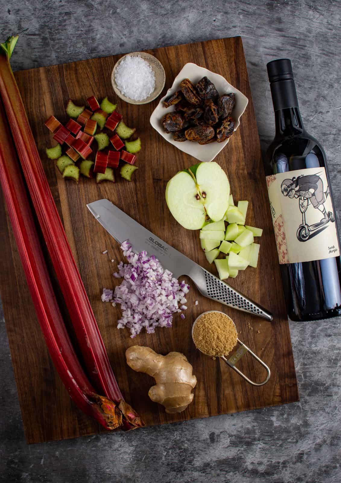 rhubarb and date chutney ingredients on a chopping board and a bottle of red wine next to them