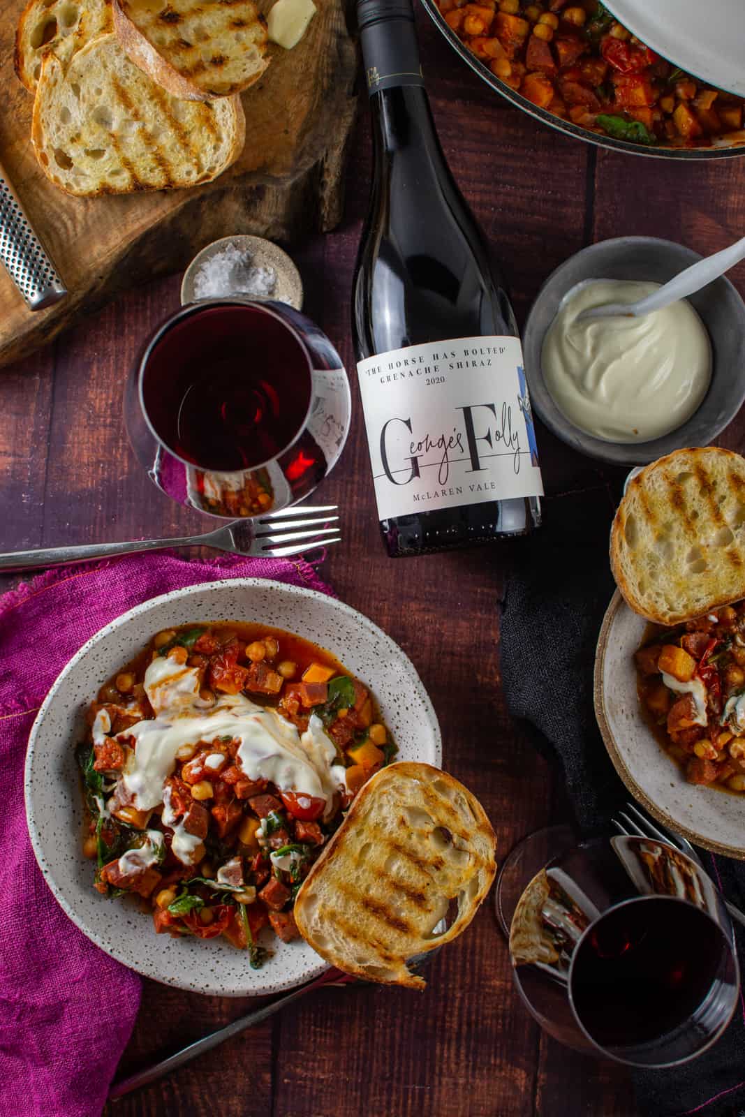chorizo and chickpea stew on wooden table, georges folly wine and some toast