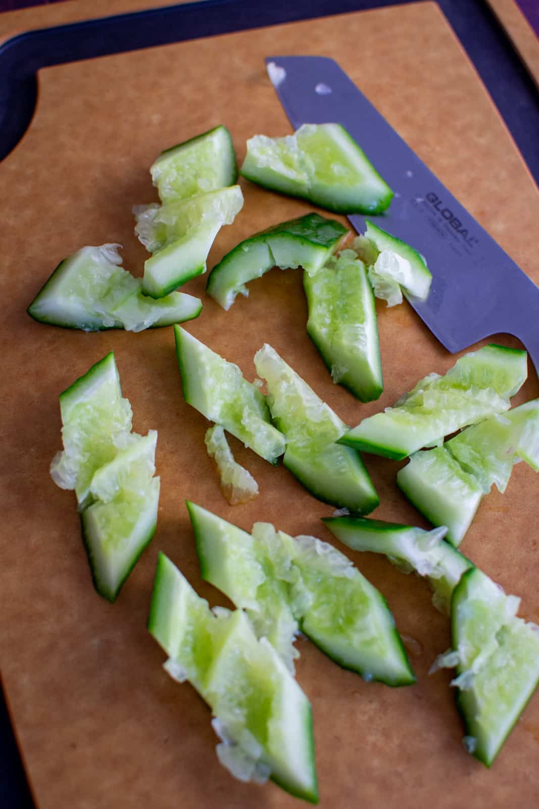 smashed cucumber on chopping board 