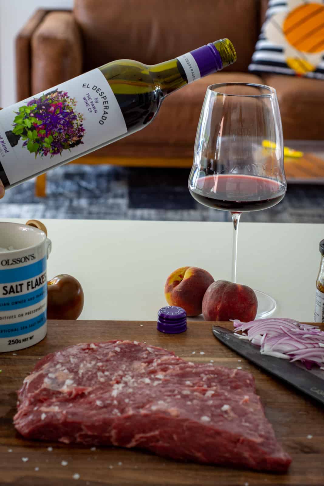 bavette steak on a chopping board with red wine being poured