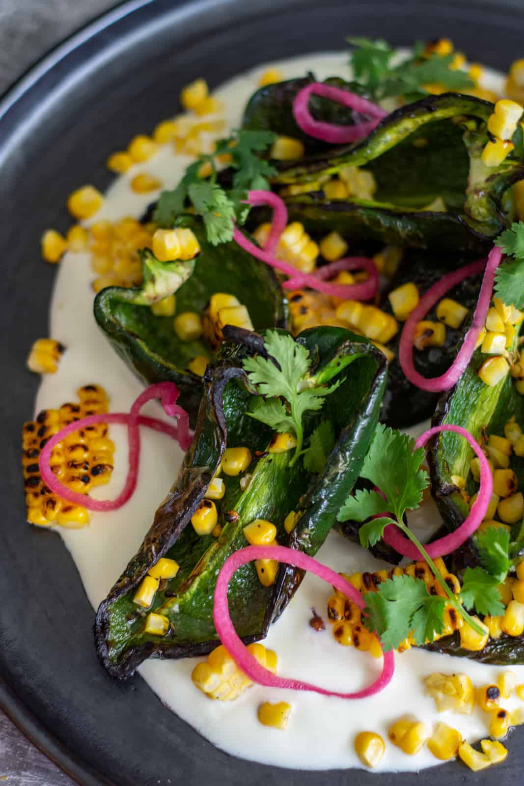 Close up of grilled poblanos salad on a black plate