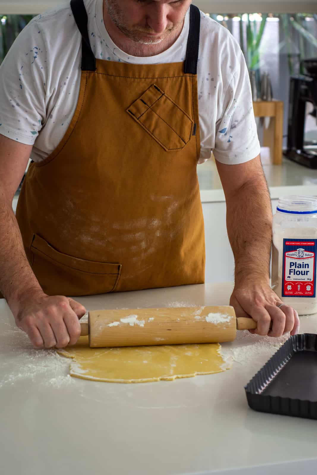 someone rolling out pastry on a kitchen counter top