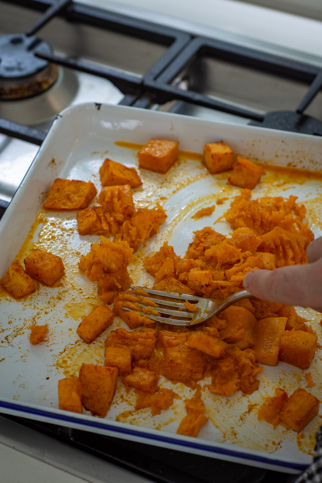 squashing butternut squash on a making tray
