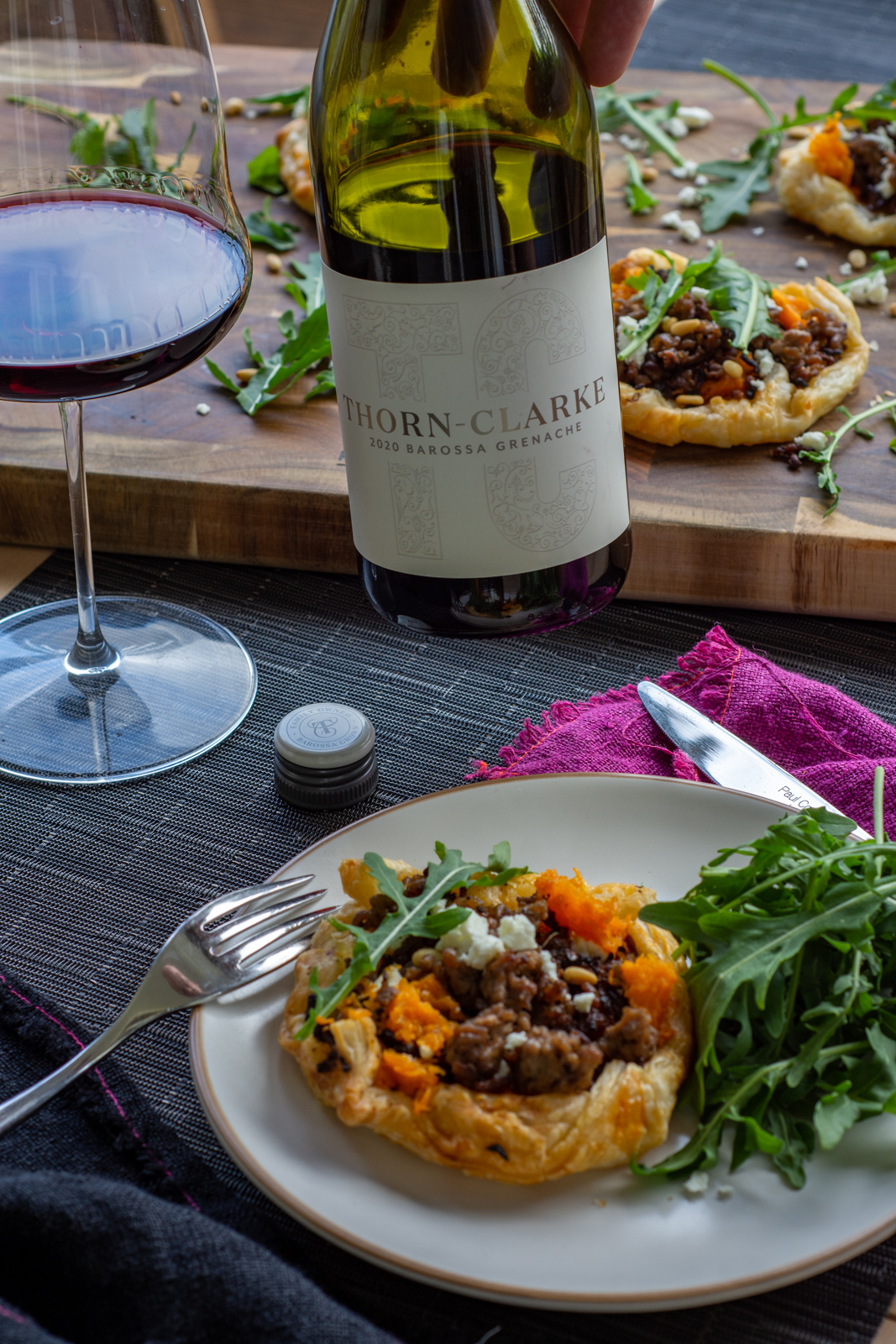 savour lamb mince tart on a plate with someone holding a bottle of grenache