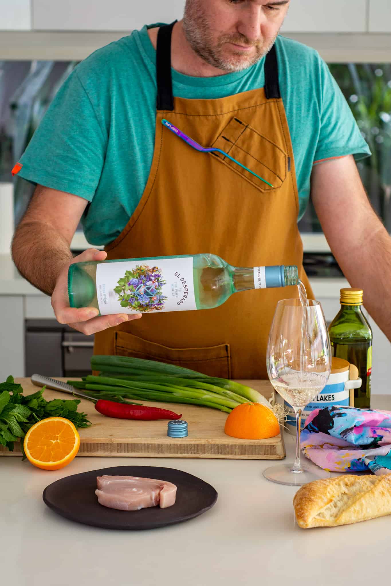 someone in the kitchen with grilled swordfish ingredients and El Desperado pinot grigio