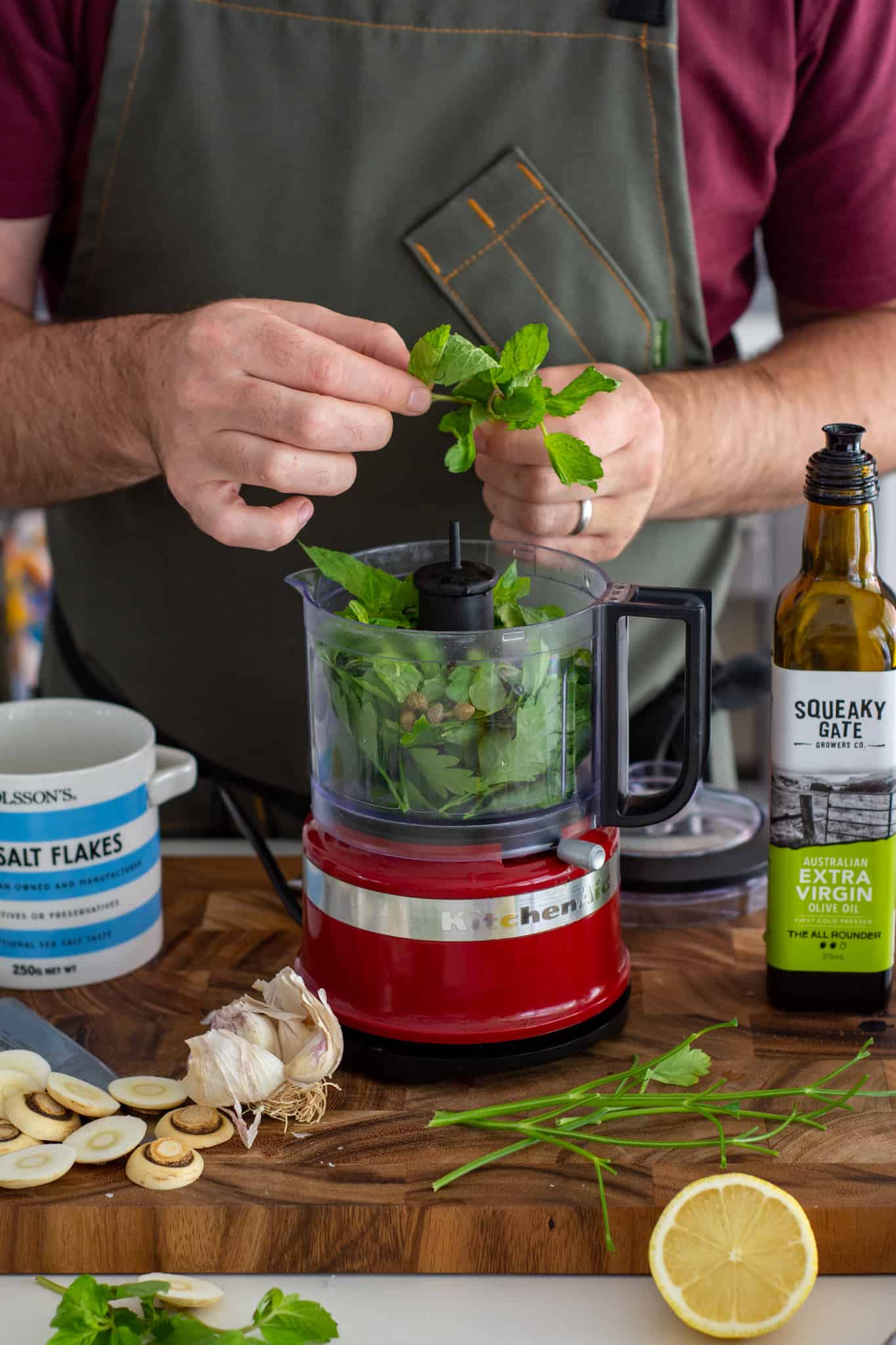 someone picking mint to put into a small food processor in the kitchen