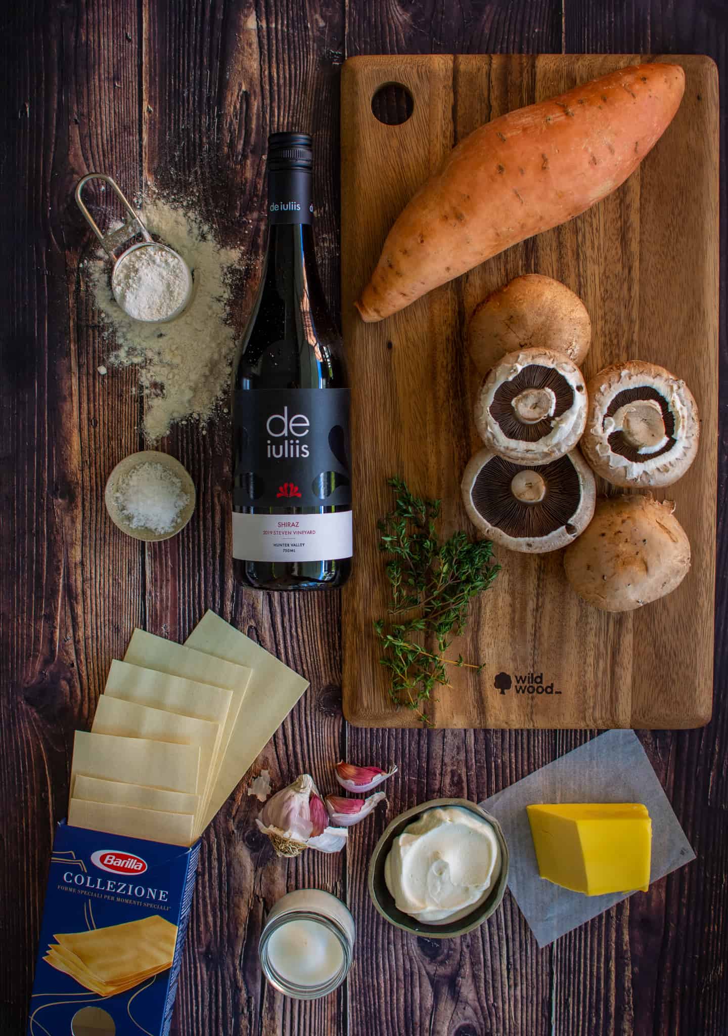 Vegetable lasagne ingredients on chopping board and on wooden table